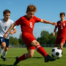 Youth soccer players competing in an intense match on a grass field